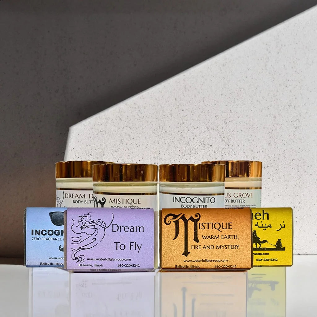 Four body butter jars sitting behind four bar soaps on top of a marble countertop