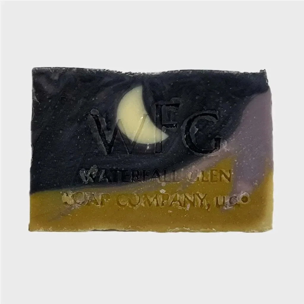 moonlight over morocco with an upper black and purple color, with a moon shape inside the bar of soap. While a yellow and purple color on the bottom of the bar soap