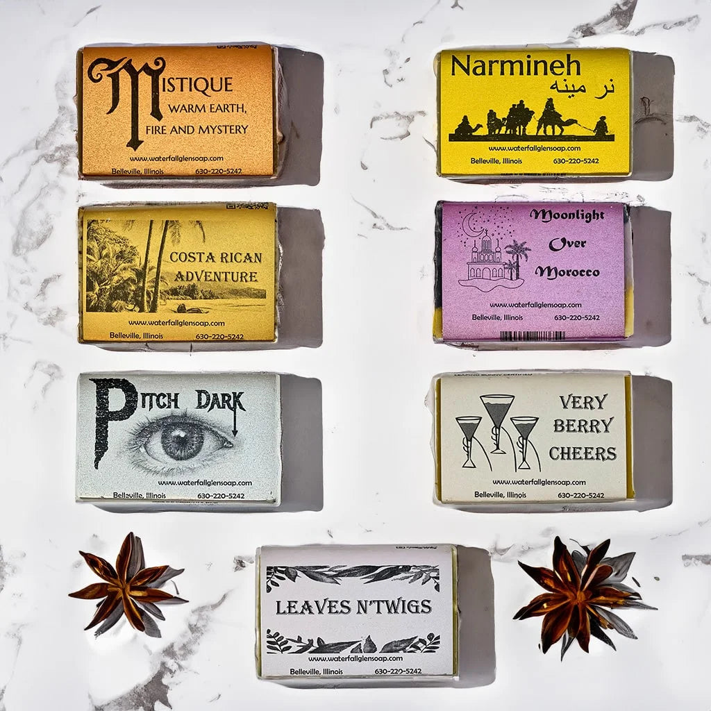7 spice scented soap bars lying on top of a marble countertop surrounded by spice ingredients